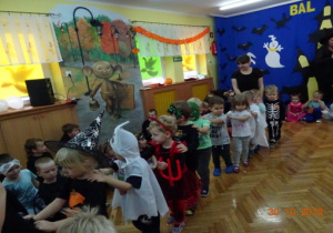 Dzieci tańczą w rzedzie z nauczycielką.